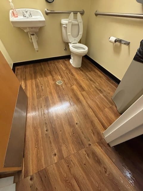 Commercial restroom cleaned and sanitized by AICS with the floor waxed